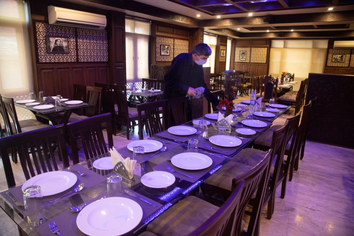 A Kashmiri waiter cleans a table inside a restaurant of Hotel Standard during lockdown to stop the spread of the coronavirus in Srinagar, Indian controlled Kashmir, July 15, 2020. The only activity in