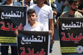 Palestinians hold banners reading "normalization is a treason" during a protest against the United Arab Emirates'' deal with Israel to normalise relations, in Gaza City August 14, 2020.