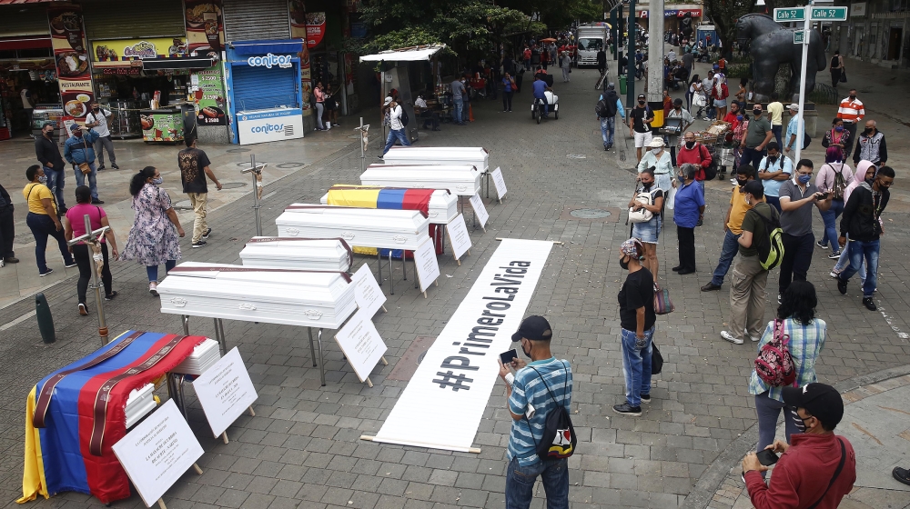 Some citizens look at the coffins placed in the street as a symbolic act of rejection of the recent massacres in the country, in Medellin, Colombia, 24 August 2020. Civil organizations carried out on 