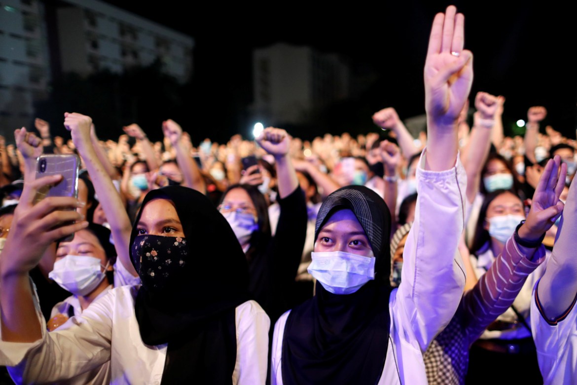 Pro-democracy student wearing masks do the three-fingered salute at a rally to demand the government to resign, to dissolve the parliament and to hold new elections under a revised constitution, at Ma