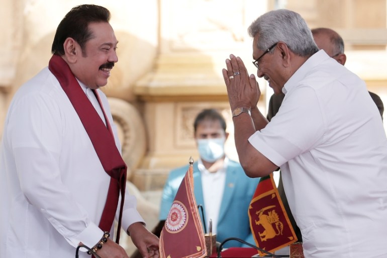 Sri Lanka''s former leader Mahinda Rajapaksa and his brother, and Sri Lanka''s President Gotabaya Rajapaksa gesture during the swearing in ceremony at Kelaniya Buddhist temple in Colombo
