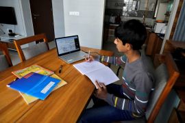 A student makes notes as he attends an online class at his home after Gujarat government ordered the closure of schools and colleges across the state amid coronavirus disease (COVID-19) fears, in Ahme