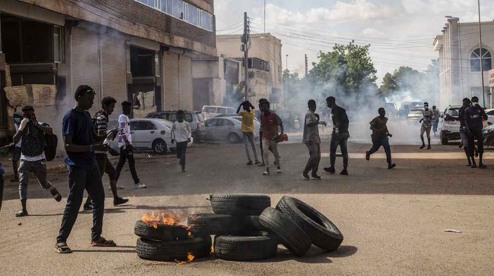Sudanese demonstrators burn tires to make barricades and to close roads after Sudanese security forces intervene them during the demonstration to commemorate the first anniversary of a transitional de