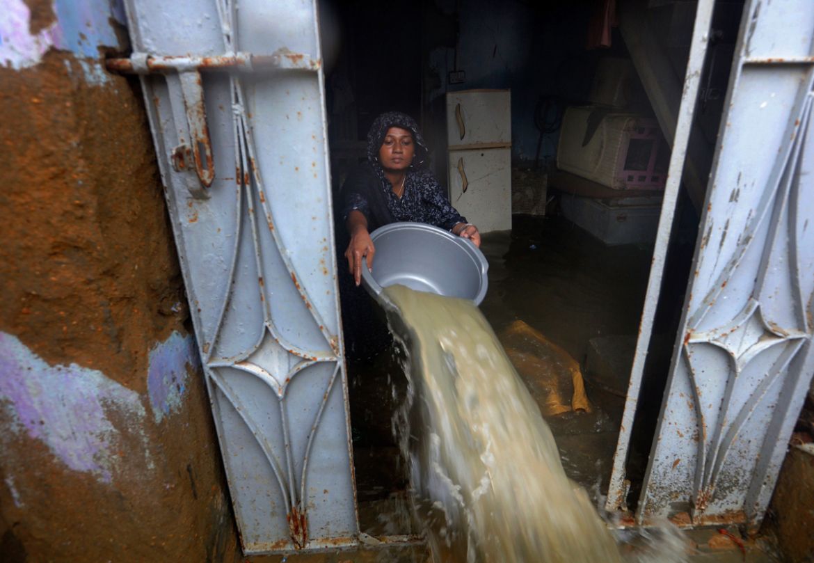 A woman bails water from her house after heavy monsoon rains, in Karachi, Pakistan, Tuesday, Aug. 25, 2020. Three days of monsoon rains have killed dozens of people and damaged hundreds of homes acros