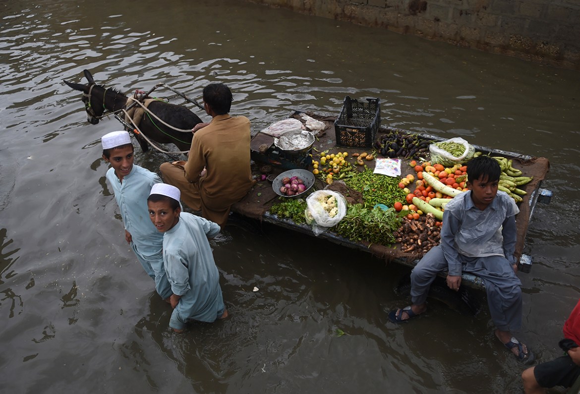 A vegetable vendor rides on his donkey cart through a flooded street after heavy monsoon rains in Pakistan''s port city of Karachi on August 25, 2020. (Photo by Rizwan TABASSUM / AFP)