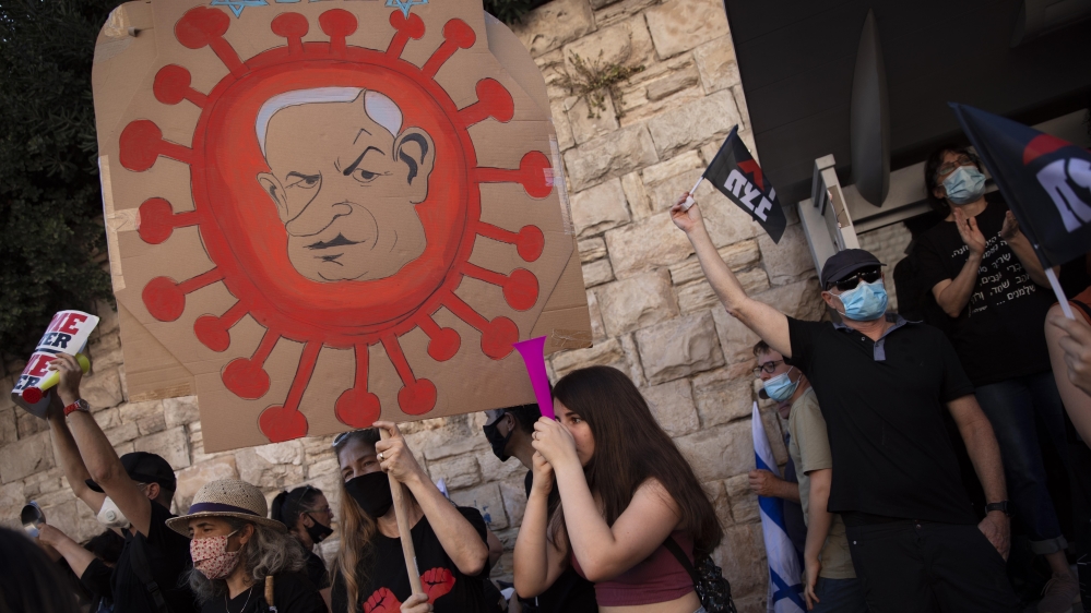 A protester holds a sign depicting Prime Minister Benjamin Netanyahu