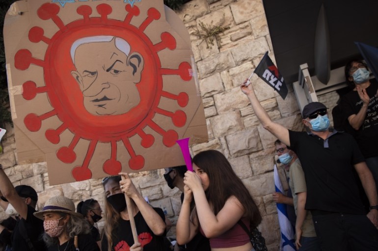 A protester holds a sign depicting Prime Minister Benjamin Netanyahu