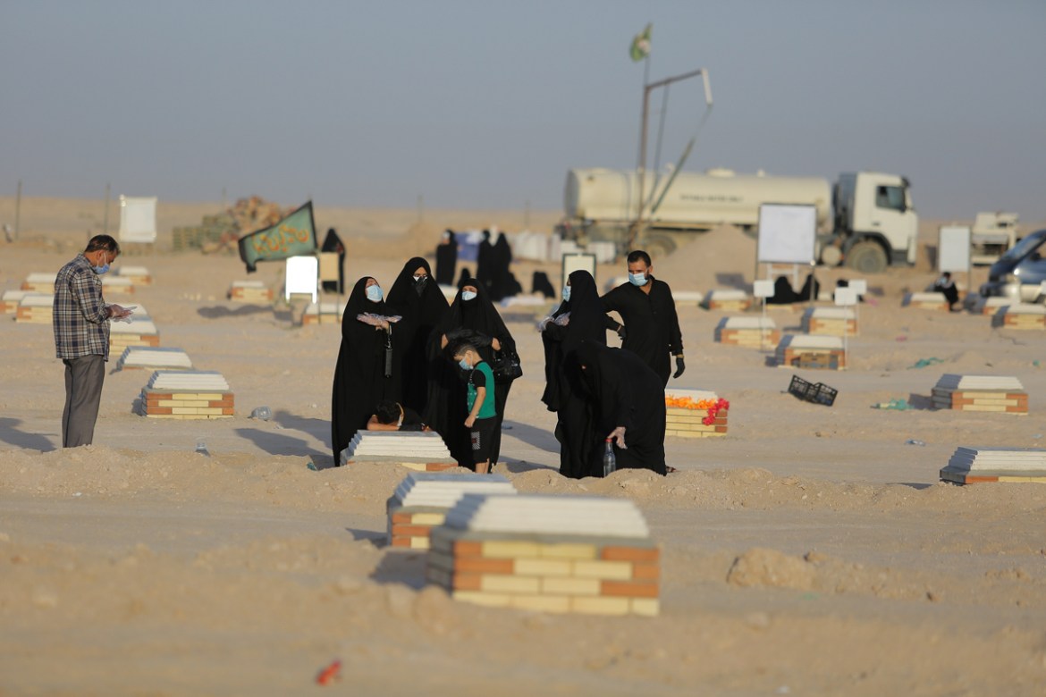 Family visits a grave of a coronavirus victim at Wadi al-Salam cemetery near Najaf, Iraq, Monday, July 20, 2020. A special burial ground near the Wadi al-Salam cemetery has been created specifically f