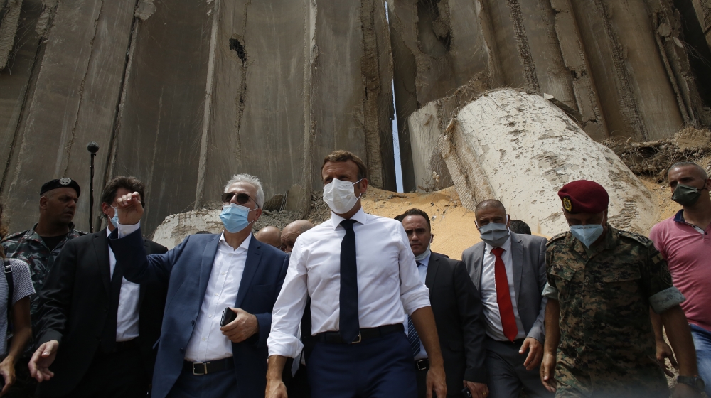 French President Emmanuel Macron, center, visits the devastated site of the explosion at the port of Beirut, Lebanon, Thursday Aug.6, 2020. French President Emmanuel Macron has arrived in Beirut to of