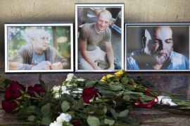 Flowers are placed by portraits of slain journalists Alexander Rastorguyev, Kirill Radchenko and Orkhan Dzhemal,