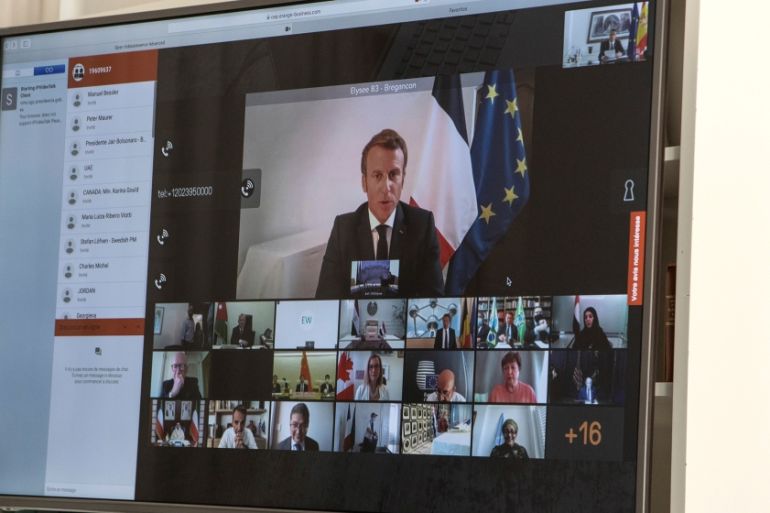 A handout photo made available by the office of the prime minister of Spain (La Moncloa) shows French President Emmanuel Macron (on screen) participates via a video connection with world leaders about
