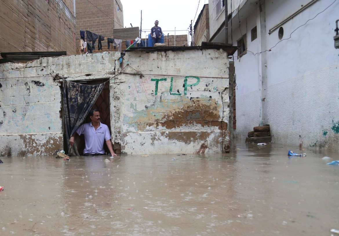epa08625208 People wait for relief goods after heavy rains in Karachi, Pakistan, 25 August 2020. Sindh provincial government declared a rain emergency after heavy monsoon rain flooded several areas of