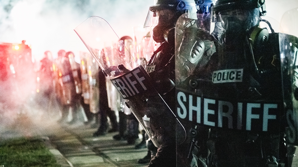 KENOSHA, WI - AUGUST 25: Law enforcement hold a line on August 25, 2020 in Kenosha, Wisconsin. As the city declared a state of emergency curfew, a third night of civil unrest occurred after the shooti