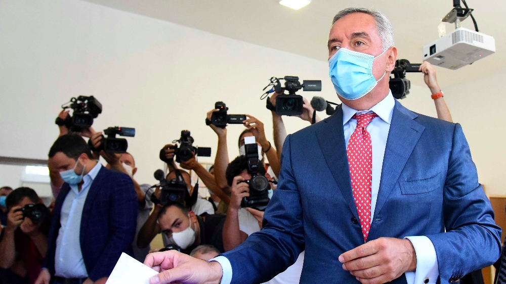Montenegrin President Milo Djukanovic wearing a mask against the spread of the new coronavirus casts his ballot to vote in parliamentary elections at a polling station in Podgorica, Montenegro