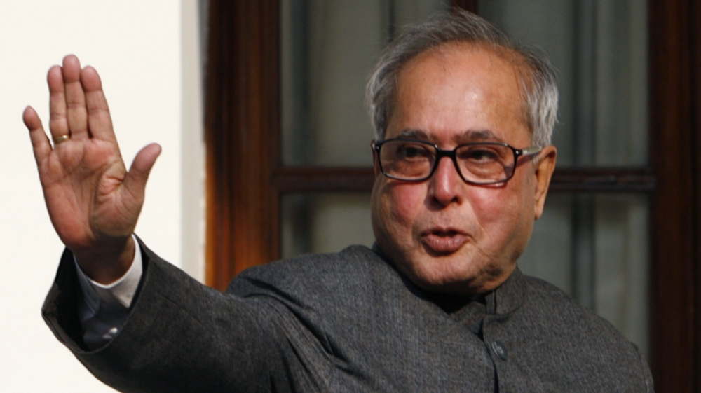 Indian Foreign Minister Mukherjee waves to the media in New Delhi