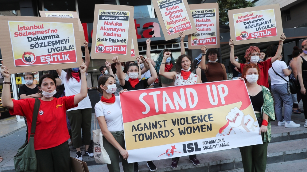 Women wearing face masks hold signs in Ankara, on August 5, 2020, during a demonstration to demand the government does not withdraw from the Istanbul Conventio, a landmark treaty, on preventing domest