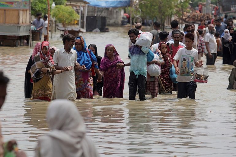 Local residents navigates through a flooded area caused by heavy rainfall in Karachi, Pakistan, Saturday, Aug. 22, 2020. (AP Photo/Fareed Khan)