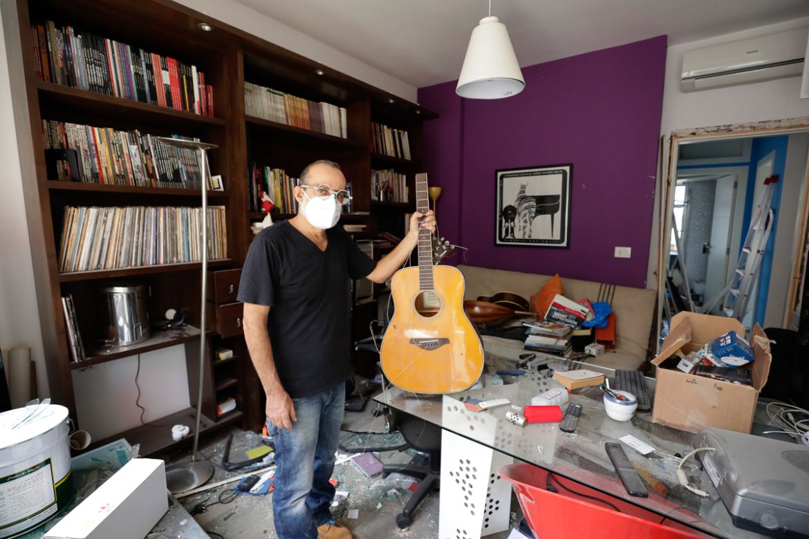 Alain Shoucair, 38, poses for a photograph as he holds his broken guitar at his destroyed apartment after Tuesday''s explosion in the seaport of Beirut, Lebanon, Thursday, Aug. 6, 2020. The gigantic ex