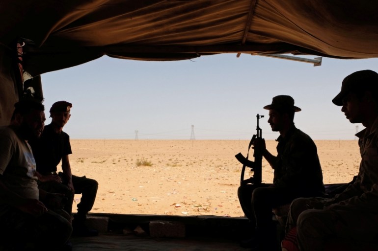 Members of the Libyan National Army (LNA) commanded by Khalifa Haftar sit inside a tent at one their sites in west of Sirte