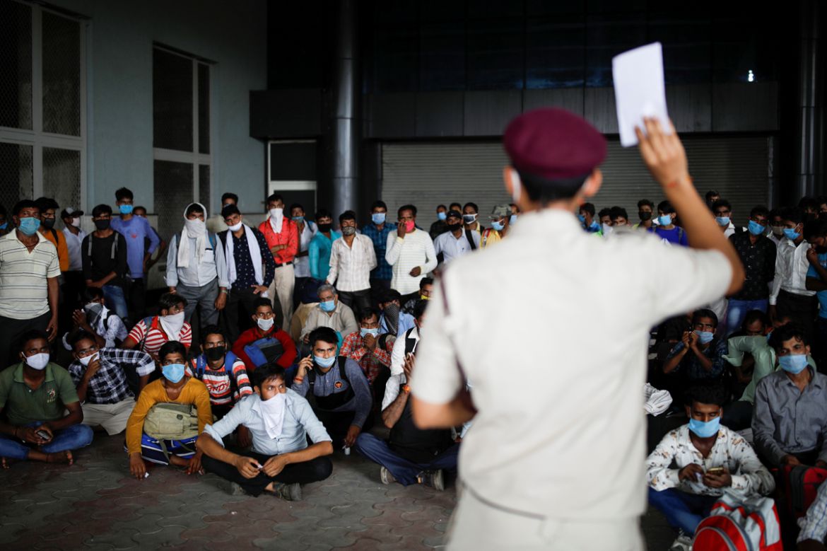 Migrant workers, who returned to Delhi from their native state, wait for their rapid antigen test report, at a bus terminal, amidst the coronavirus disease (COVID-19) outbreak in New Delhi, India, Aug