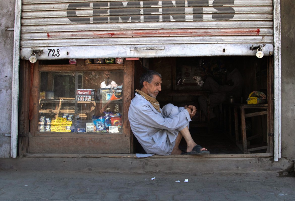 A Kashmiri shopkeeper sits at the entrance of his half closed shop during lockdown in Srinagar, Indian controlled Kashmir, July 27, 2020. Indian-controlled Kashmir''s economy is yet to recover from a c