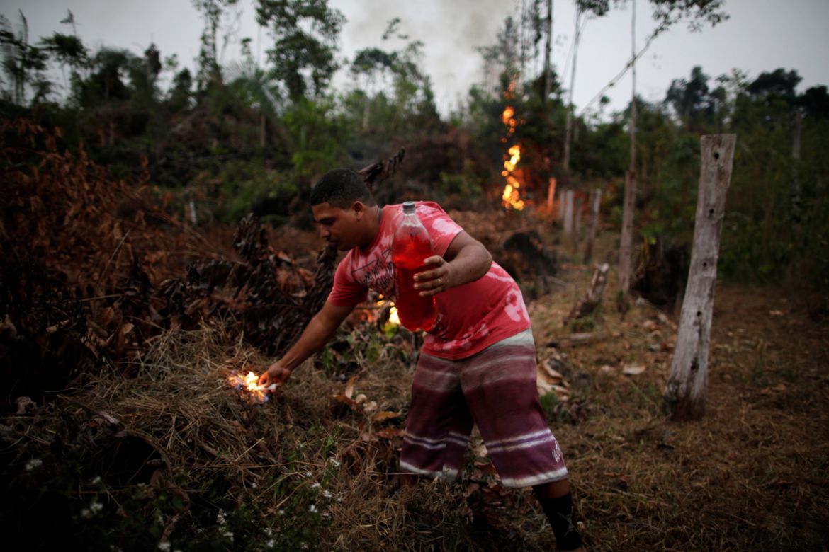 A man lights a fire to create a firebreak to stop the progress of a fire started by farmers clearing a tract of the Amazon jungle in Apui, Amazonas State, Brazil, August 11, 2020. REUTERS/Ueslei Marce