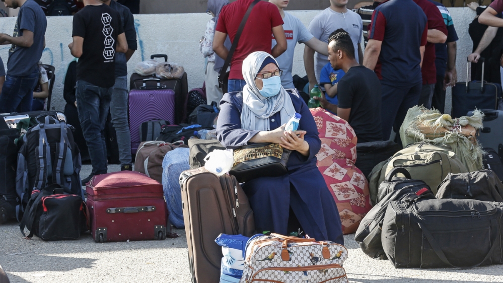 Palestinians wait to cross to the Egyptian side of Rafah border crossing after months of closure due to the coronavirus pandemic in the southern Gaza Strip, on August 11, 2020. (Photo by SAID KHATIB /