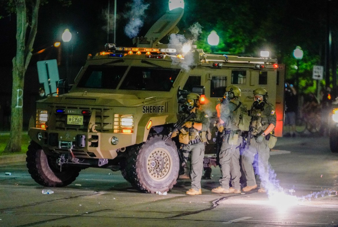 epa08623652 Law enforcement officers wear riot gear as they face angry crowds during a second night of unrest in the wake of the shooting of Jacob Blake by police officers, in Kenosha, Wisconsin, USA,