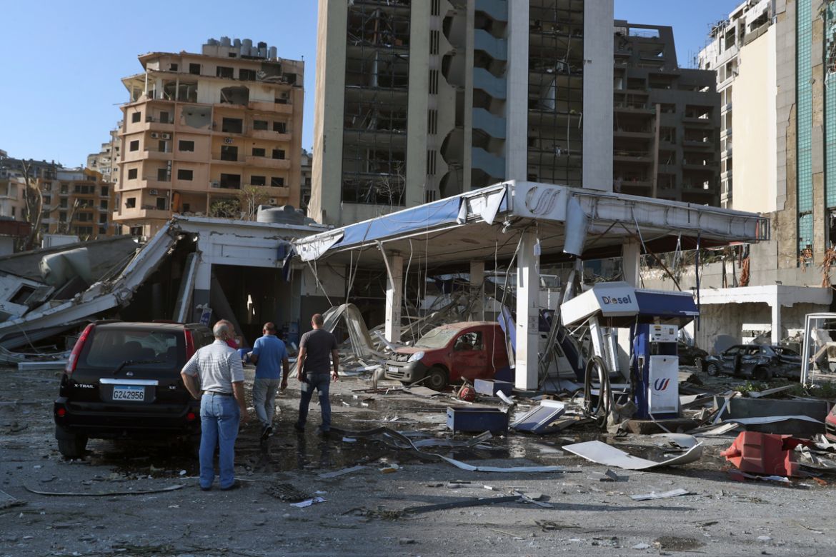 People inspect a damaged gas station near the scene of an explosion that hit the seaport of Beirut, Lebanon, Wednesday, Aug. 5, 2020. A massive explosion rocked Beirut on Tuesday, flattening much of t