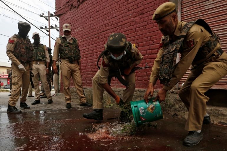 Indian police clean the scene of attack on security personnel by suspected militants ahead of India''s Independence Day, in Srinagar