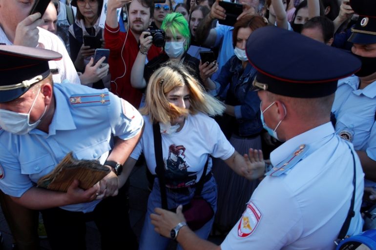 Police officers detain a demonstrator during an anti-Kremlin rally in Saint Petersburg