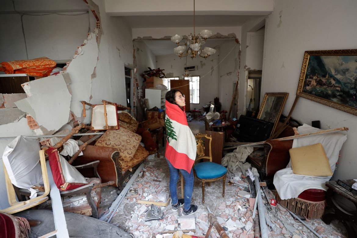 Farah Mahmoud, wrapped in Lebanese national flag, checks her parents destroyed apartment after Tuesday''s explosion in the seaport of Beirut, Lebanon, Thursday, Aug. 6, 2020. The gigantic explosion in