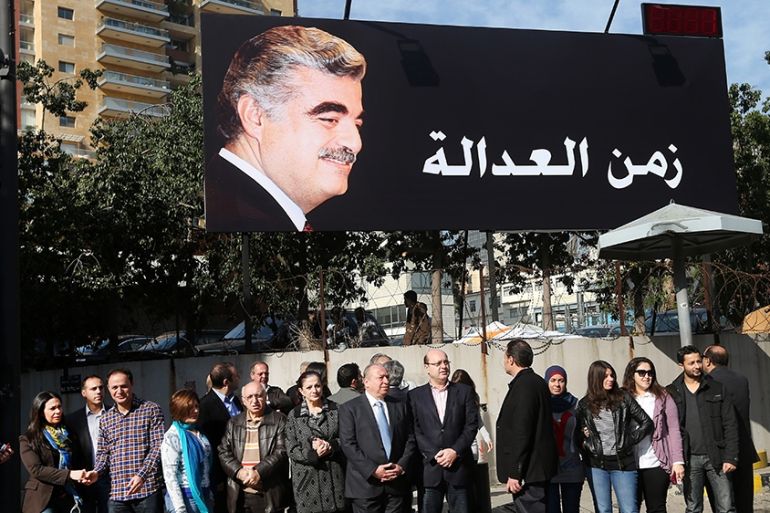 Supporters of slain former Lebanese Prime Minister Rafik Hariri, gather under a giant billboard with his portrait and Arabic that reads, "time for justice," a few hundred of meters (yards) from the si