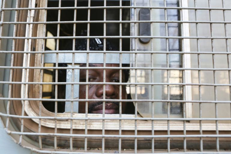 Zimbabwe Journalist Hopwell Chin''ono is seen through the window of a prison truck upon his arrival at the magistrates courts for his bail ruling in Harare, Monday, Aug, 24, 2020. A magistrate has deni