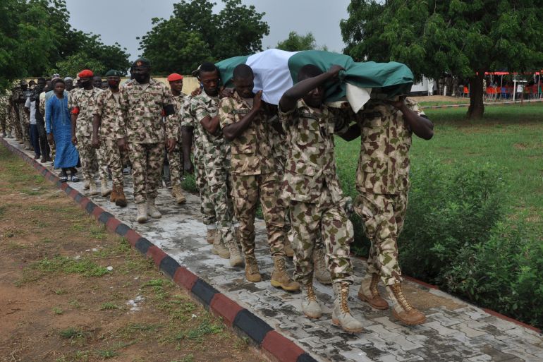 Nigerian soldiers carry the body of a fellow serviceman during his funeral on September 26, 2020 as victims are buried following an attack in Borno, Nigeria