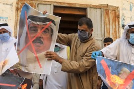 Palestinian men burn the exed out portraits of the Bahraini King, US President and Israeli Premier during a protest in Deir al-Balah, in central Gaza Strip, on September 12, 2020, to condemn the norma