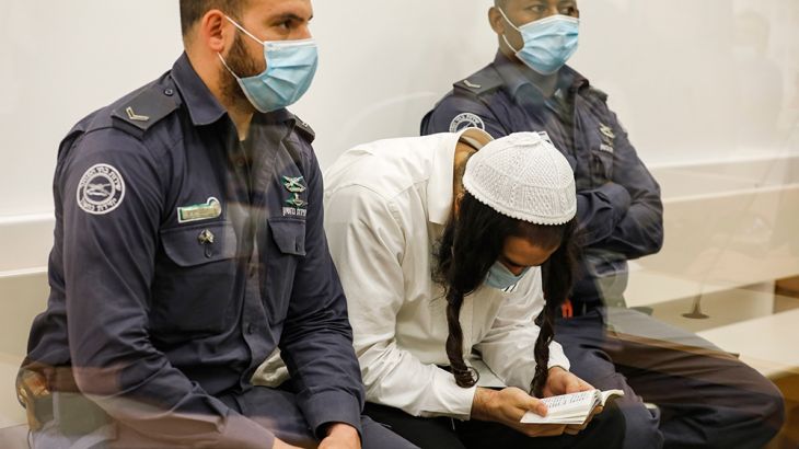Amiram Ben-Uliel, a Jewish extremist convicted for the Duma arson murder reads while waiting during a sentencing hearing at the central district court of Israel''s central city of Lod on June 9, 2020.