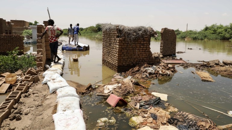 A man passes on the side of a flooded road in the town of Alkadro, about (20 km) north of the capital Khartoum, Sudan, Saturday, Sept. 5, 2020. Sudanese authorities have declared their country a natur