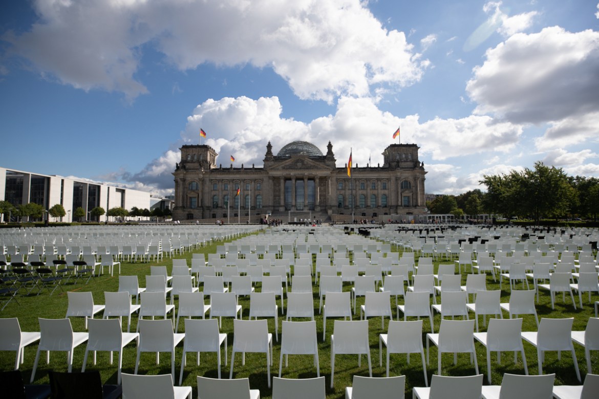 epa08652297 Activists from Seebruecke and Sea-Watch put chairs on the grass of the Platz der Republick in front of the German parliament Bundestag building in Berlin, Germany, 07 September 2020. As a