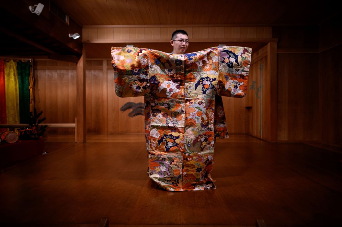 This photo taken on July 29, 2020 shows performer Kennosuke Nakamori posing for a photo with a costume after an interview with AFP at the Kamakura Noh Theatre in the town of Kamakura in Kanagawa Prefe