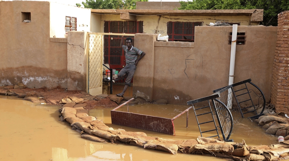 A man stands outside a flooded house in the town of Omdurman, about 18 miles (30 km) northwest of the capital Khartoum, Sudan, Wednesday, Aug. 26, 2020. (AP Photo/Marwan Ali)