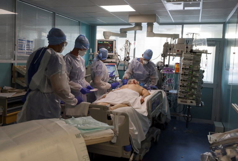 Members of the medical staff, wearing protective suits and face masks, treat a patient suffering from the coronavirus disease (COVID-19) in the Intensive Care Unit (ICU) of the military hospital Laveran in Marseille, France