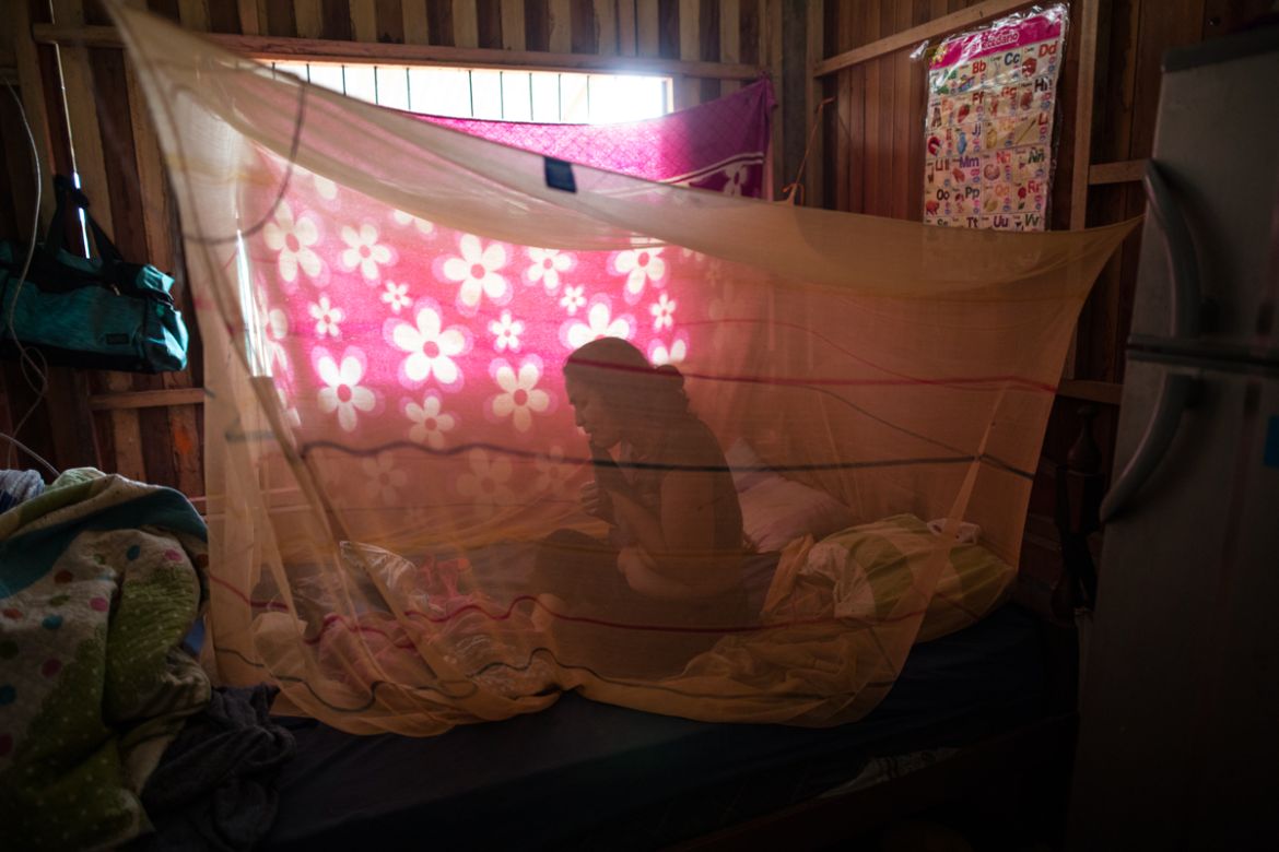 Julia Lina who has been suffering from COVID-19 symptoms, rests in her bed enclosed in mosquito netting after receiving an herbal treatment from Comando Matico volunteers, in the Shipibo Indigenous co