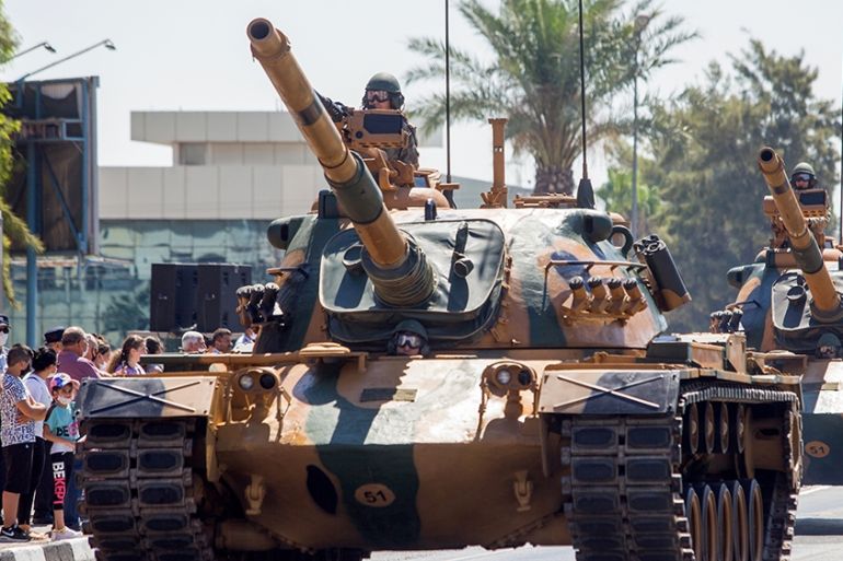 (FILES) In this file photo taken on July 20, 2020, Turkish troops parade atop armoured vehicles in the northern part of Nicosia, the capital of the self-proclaimed Turkish Republic of Northern Cyprus