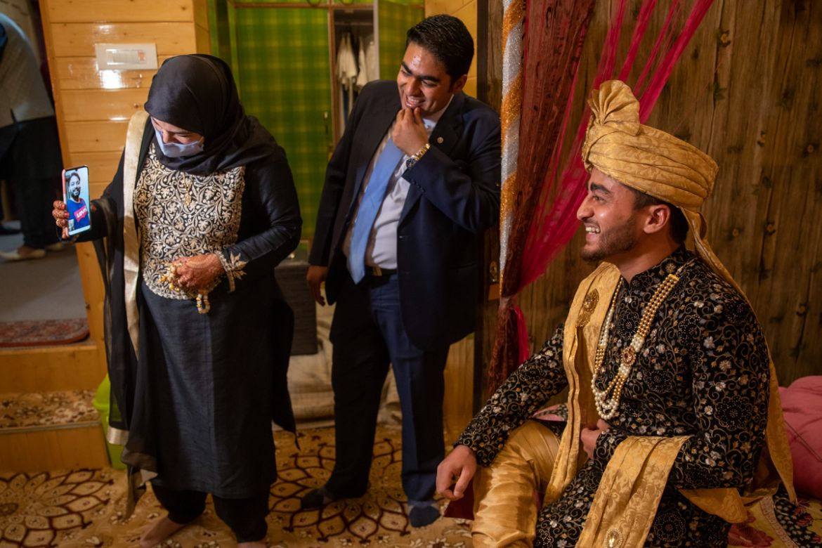Khusheeba Munir, holds the cell phone as her husband Azhar Mahmood, who tested positive for COVID-19 and was not able to attend the marriage shares a lighter moment with his cousin and groom Haseeb Mu
