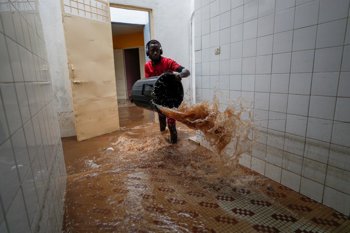 A volunteer removes water from a flooded health center after heavy rains in Guediawaye on the outskirts of Dakar, Senegal September 6, 2020. REUTERS/Zohra Bensemra TPX IMAGES OF THE DAY