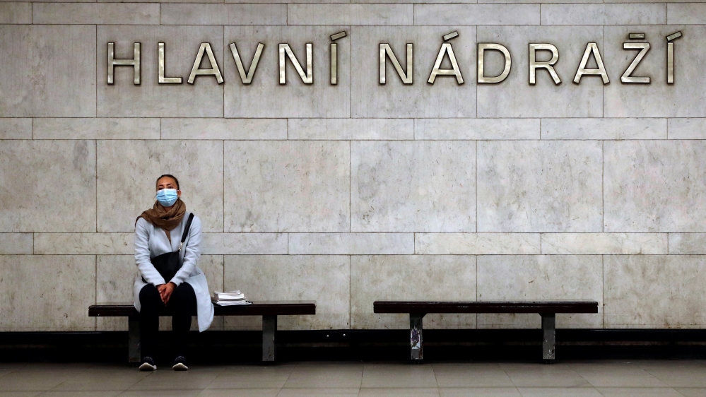 A commuter wearing a protective mask waits for a subway train in Prague