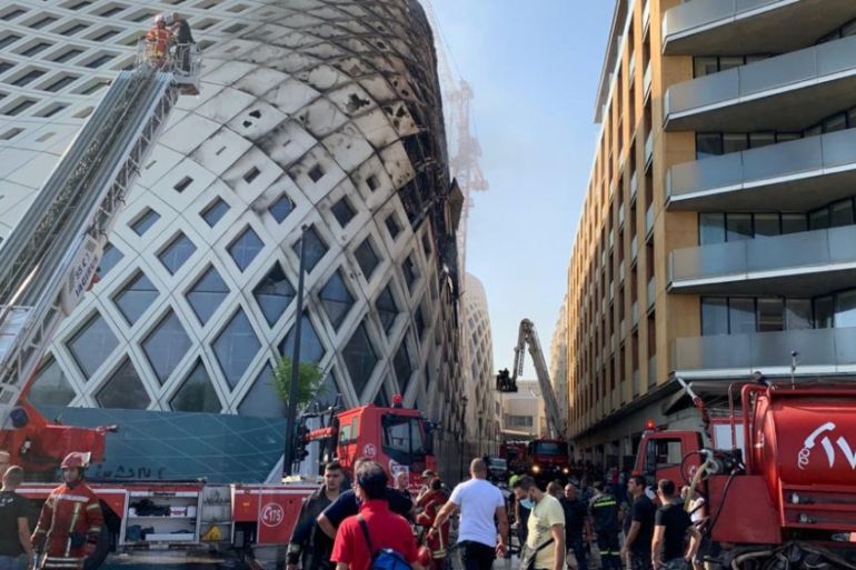 Firefighters and people gather near the site of a fire that broke out in a building in Central Beirut, Lebanon September 15, 2020. REUTERS/Ahmad el Kerdi