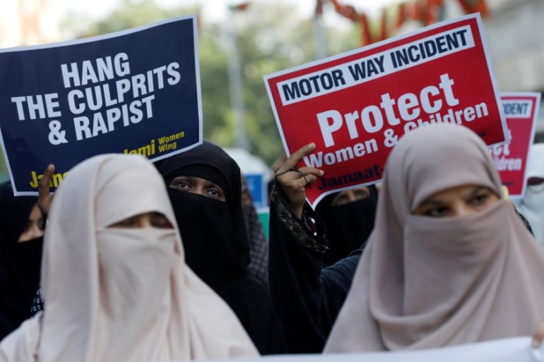 People carry signs to condemn the violence against women and girls, during a demonstration in Karachi