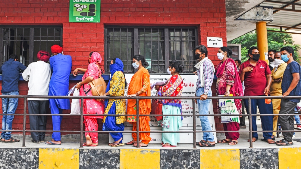People stand in a queue as they wait for their turn to collect test reports for the COVID-19 coronavirus, at a civil hospital in Amritsar on July 17, 2020. Coronavirus cases in India passed one millio